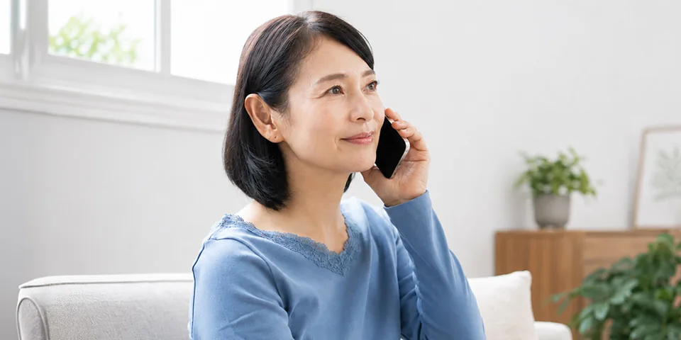 港南区民のわかりやすい家族葬へ電話で葬儀の事前相談をする女性