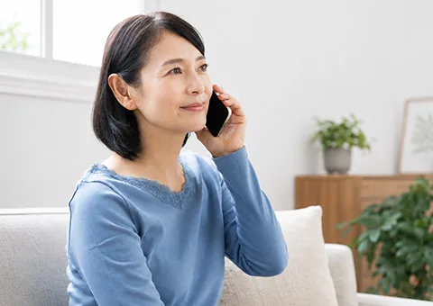 港南区民のわかりやすい家族葬へ電話で葬儀の事前相談をする女性