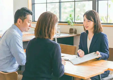 葬儀社スタッフと40代前後の夫婦が、神奈川県で行う葬儀について打ち合わせをしている様子