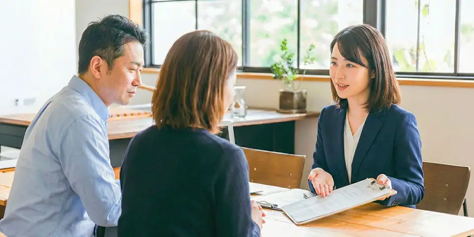 わかりやすい家族葬 はばたきグループの女性スタッフと40代前後の夫婦が、神奈川県で行う家族葬について打ち合わせをしている様子