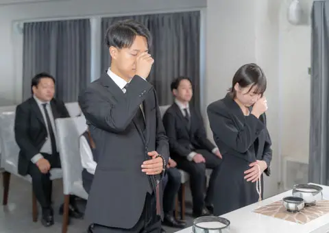 お通夜で、参列者(男性1名・女性1名)が焼香をあげている様子