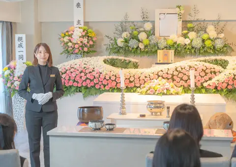 女性の司会進行スタッフが、神奈川県での告別式を進行していう様子