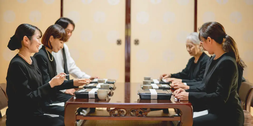 初七日法要(繰り上げ法要)で精進料理を家族で食べている様子